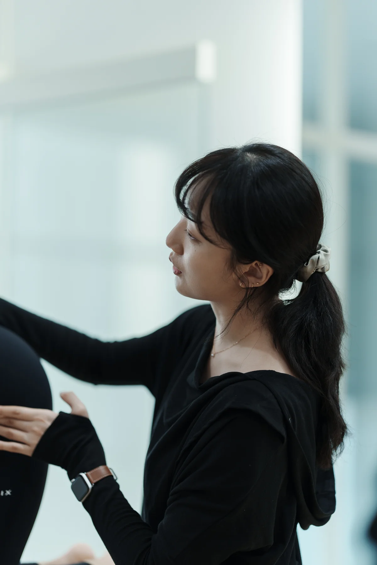 강사가 초보 수강생의 리포머 위 척추 정렬을 직접 잡아주는 장면